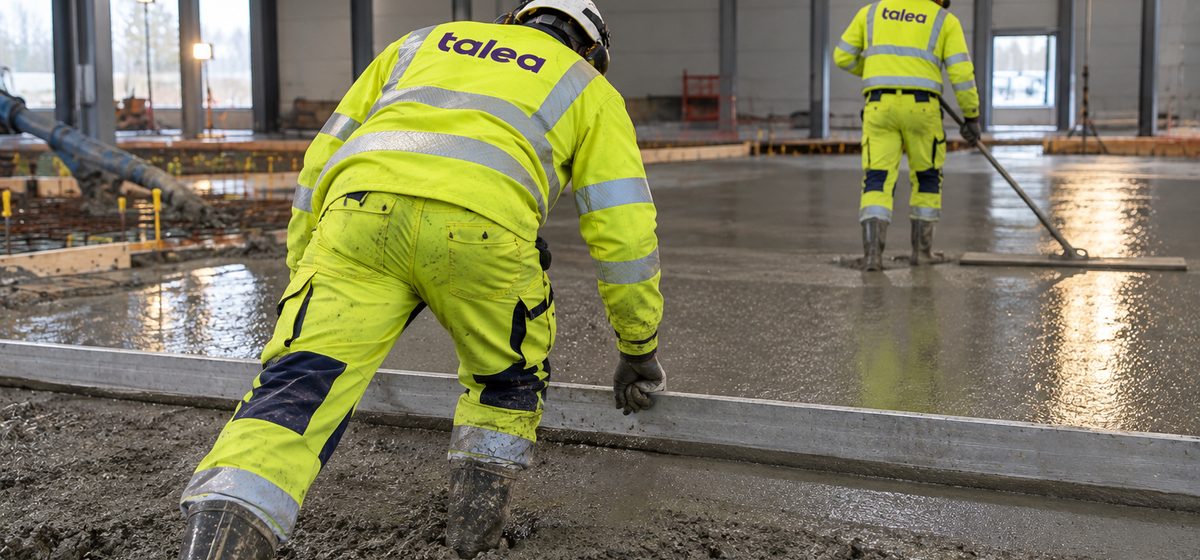 Betongarbetare från Talea drar av ett nygjutet betonggolv