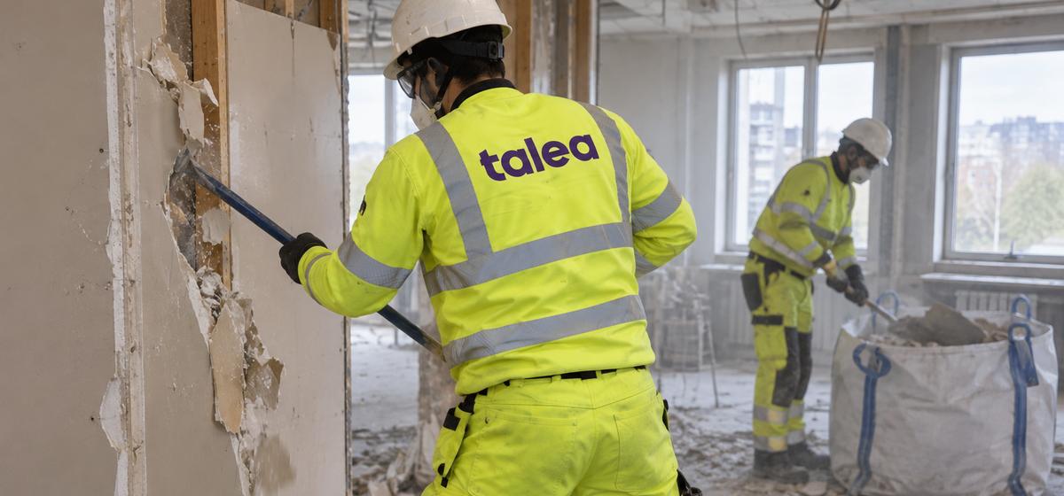 Talea-rivare river en gipsvägg vid invändig rivning