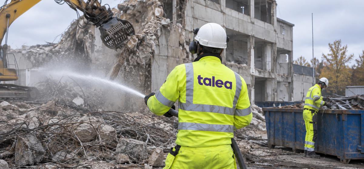 Talea-medarbetare dammbinder med vattenslang vid rivning av en industribyggnad