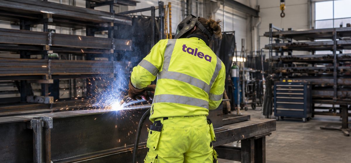 Svetsare från Talea svetsar en stålbalk i en verkstad