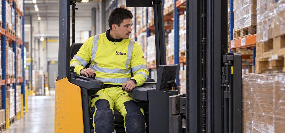 Truckförare från Talea kör skjutstativtruck mellan pallställen
