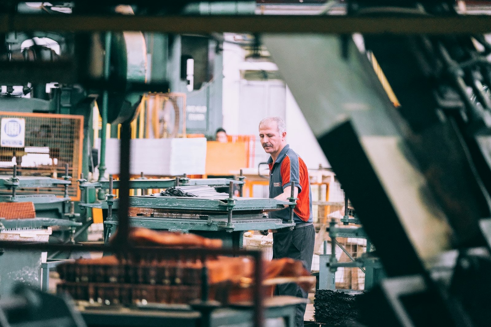 Industriarbetare vid en maskin i en produktionslokal